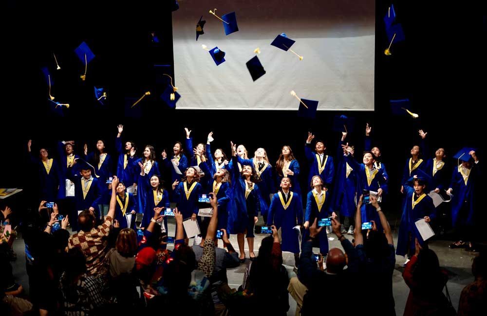 A group of graduates are throwing their caps in the air.