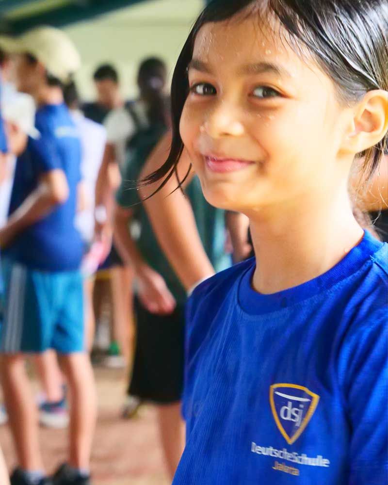 A young girl wearing a blue shirt that says ds