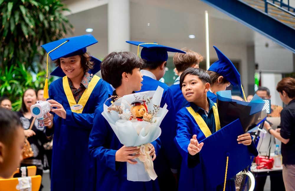 A group of graduates are standing next to each other holding a bouquet of flowers.