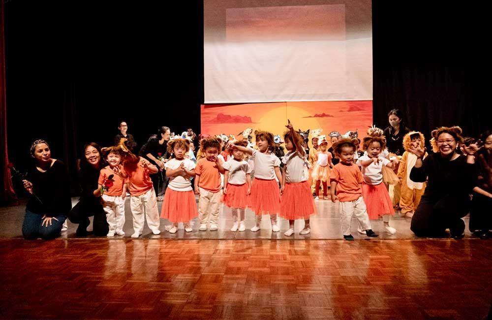 A group of children are dancing on a stage.