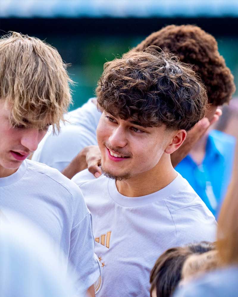 A group of young men are standing next to each other and smiling.