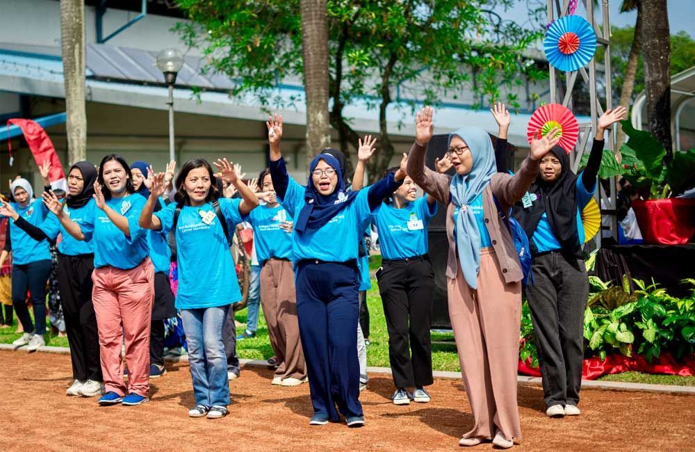 A group of women are dancing together in a park.