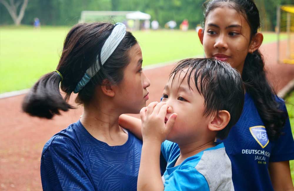 A girl and a boy are standing next to each other on a track.