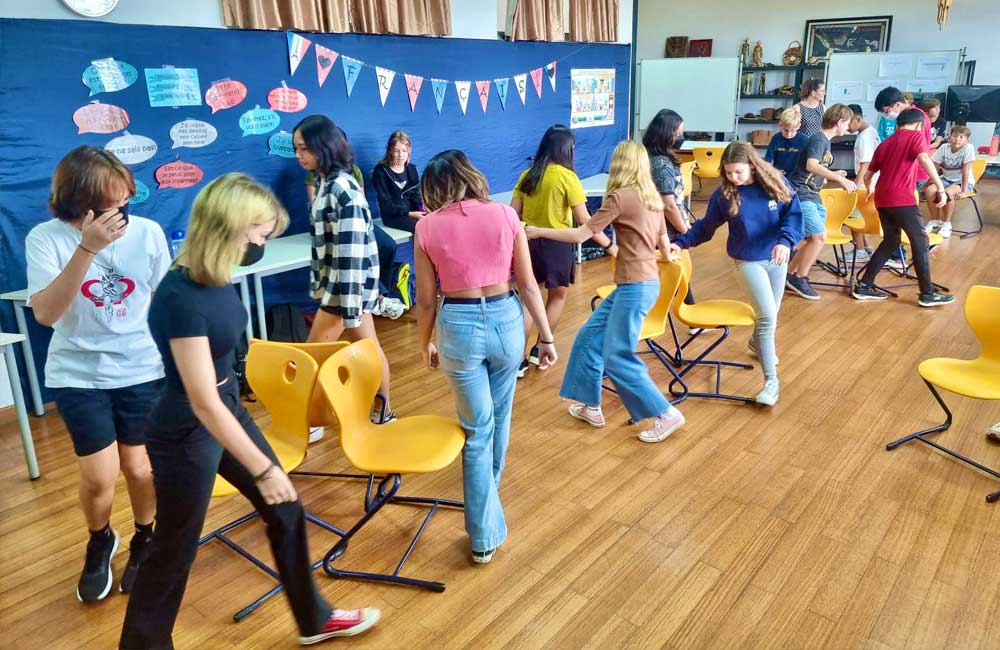 A group of young girls are dancing in a classroom.