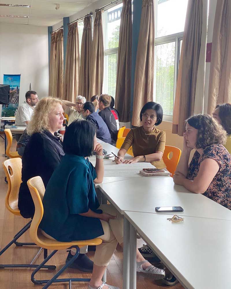 A group of people are sitting at tables in a room.