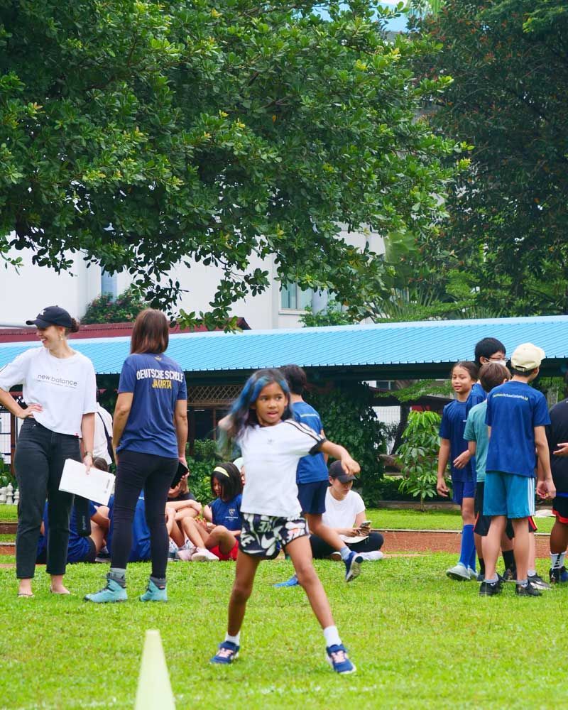 A girl wearing a shirt that says ' athletics ' on it