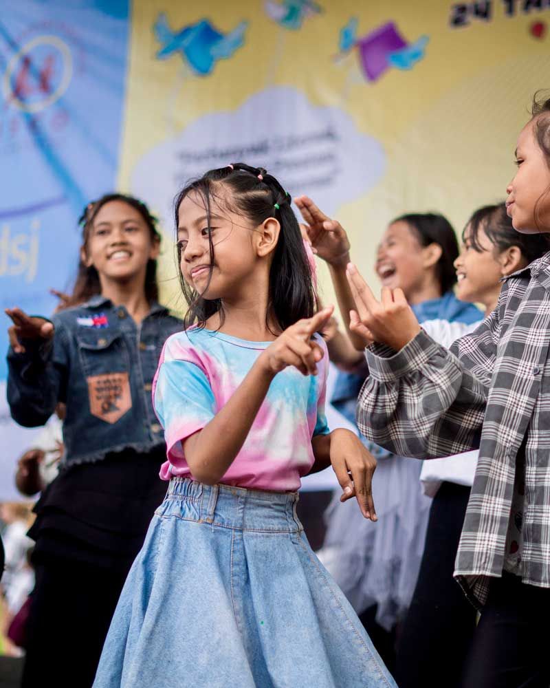 A group of young girls are dancing together on a stage.