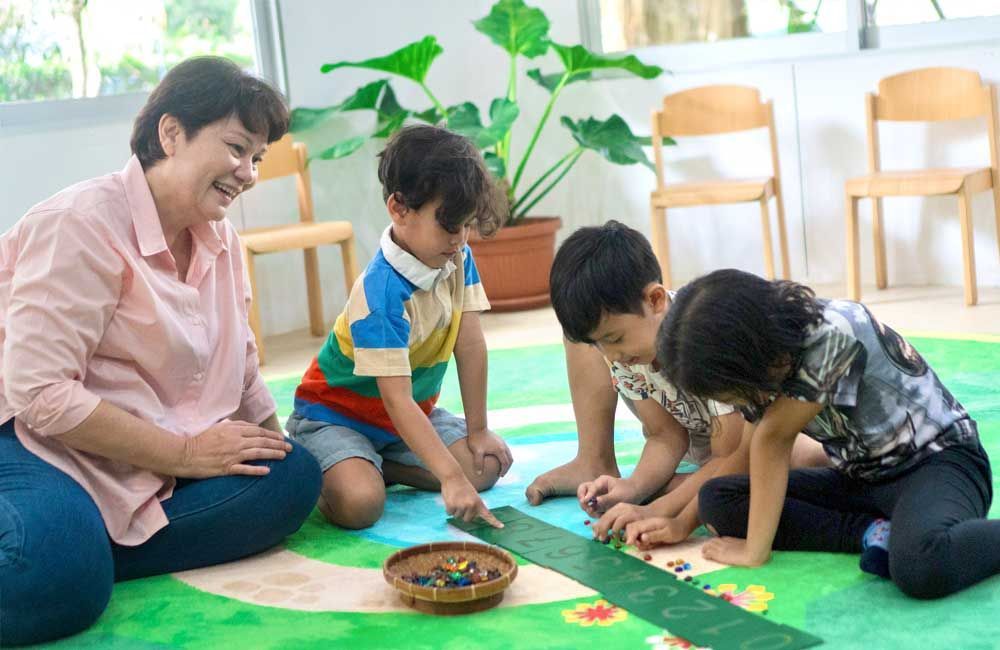 A woman is sitting on the floor playing with three children.