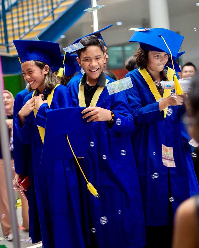 A group of young people wearing graduation gowns and caps