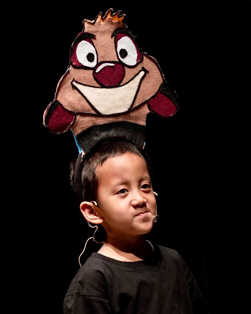 A young boy wearing a headband with a cartoon character on it