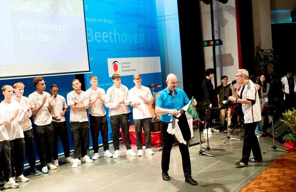 A group of people standing on a stage in front of a beethoven sign