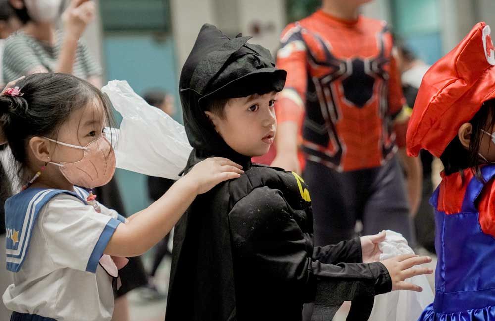 A group of children dressed in costumes are standing next to each other.