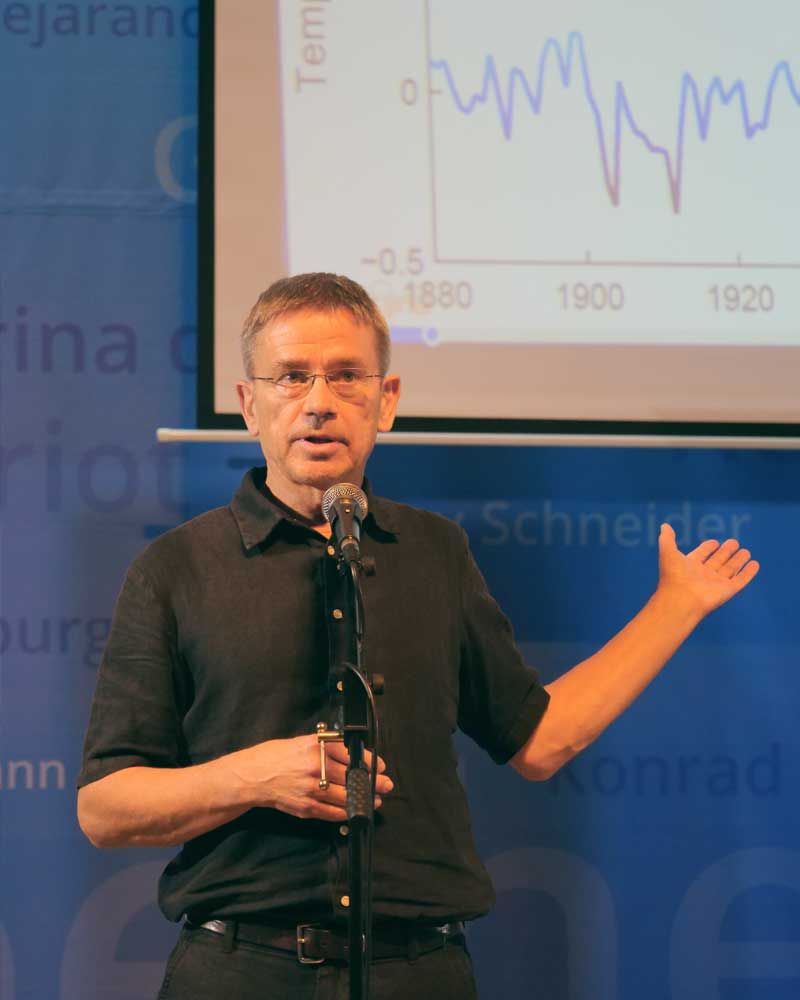 A man stands in front of a screen with a graph on it