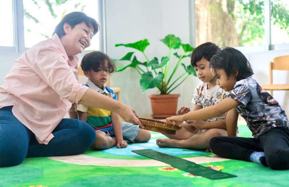 A group of children are sitting on the floor with a teacher.