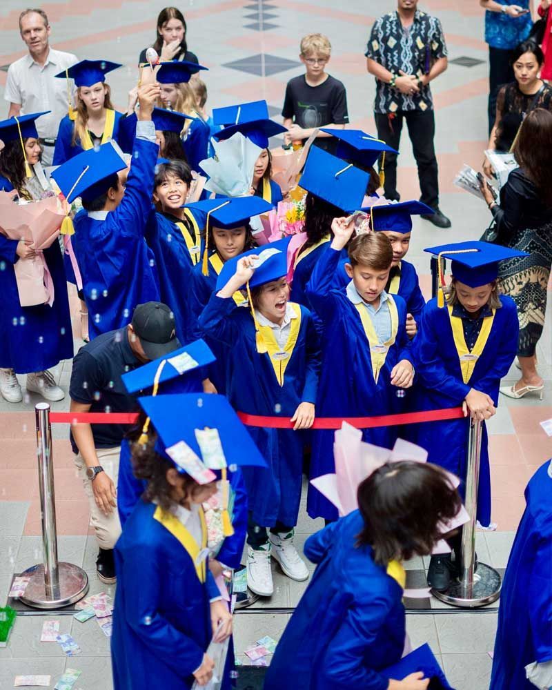 A group of people wearing blue graduation caps and gowns