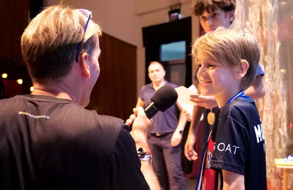 A man is talking to a young boy who is wearing a goat shirt