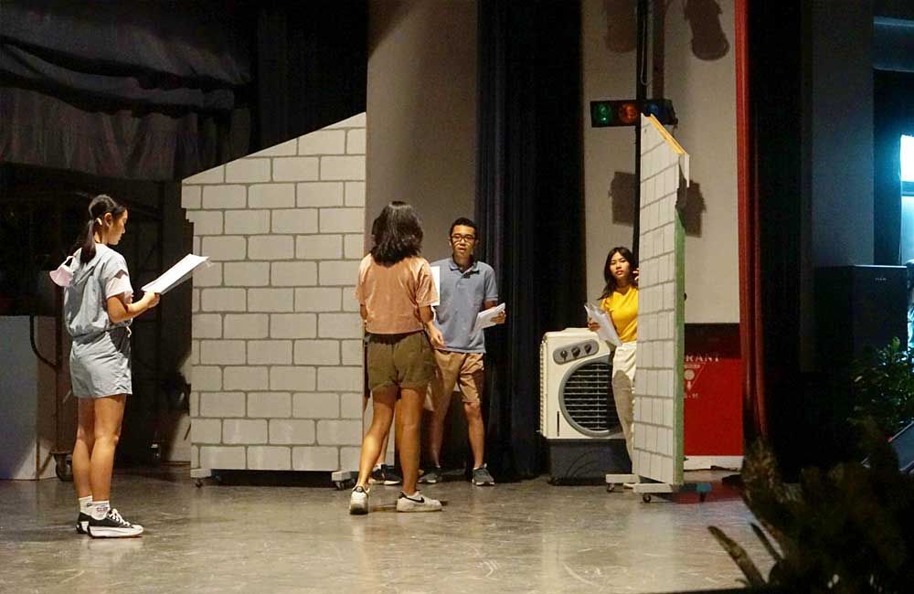 A group of people are standing on a stage in front of a brick wall.