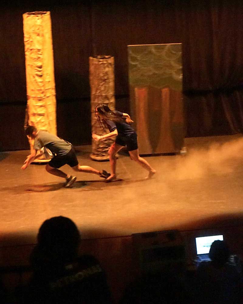 A man and a woman are running on a stage