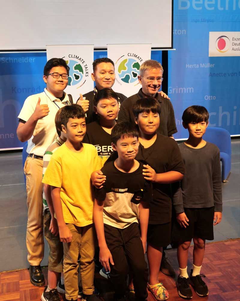 A group of young boys posing for a picture with one boy wearing a yellow shirt that says ber