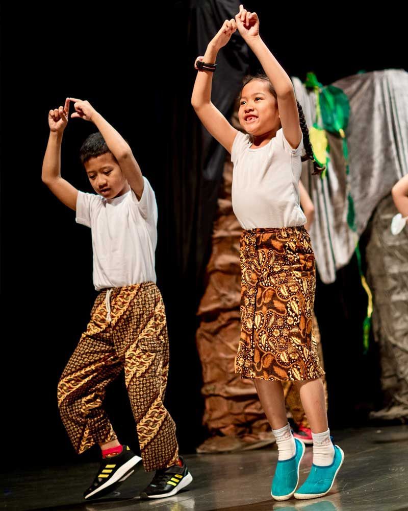 A boy and a girl are dancing on a stage.