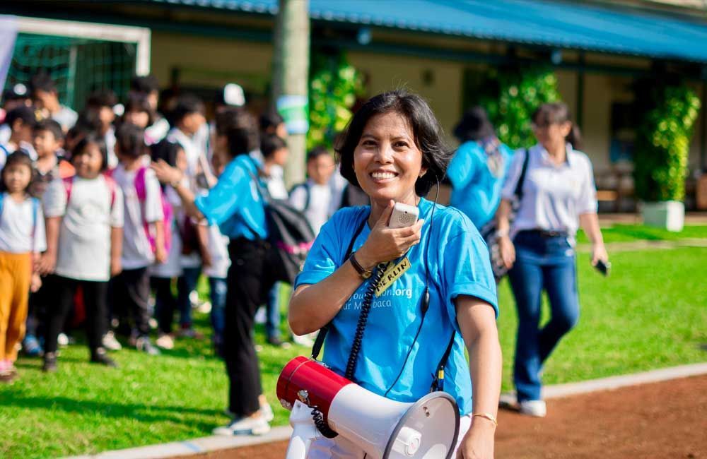 A woman is holding a megaphone in front of a crowd of people.