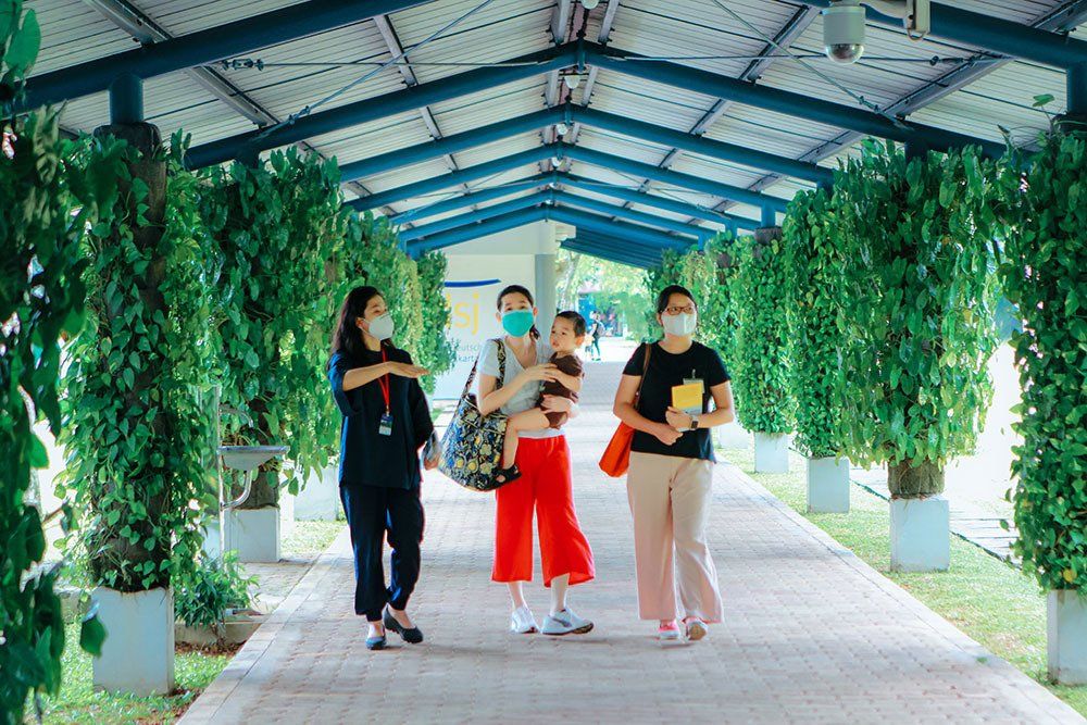 A group of women wearing face masks are walking down a path.