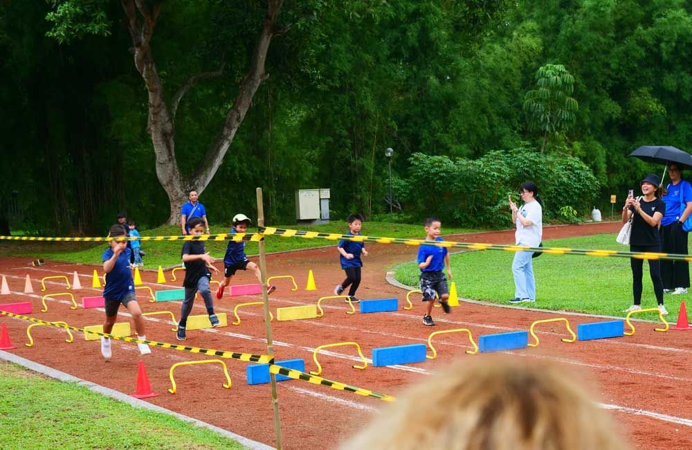 A group of children are running on a track.