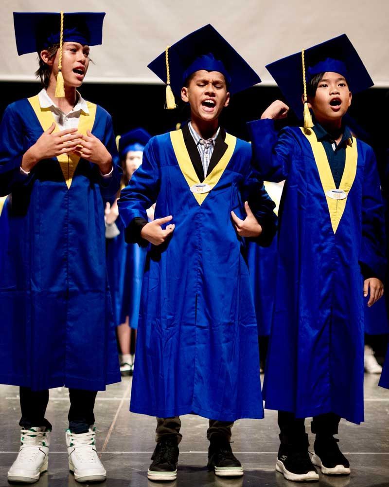 A group of children wearing graduation gowns and caps