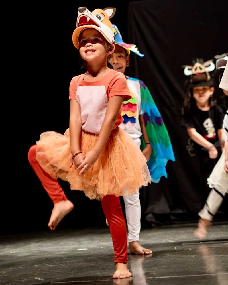 A group of young girls are dancing on a stage.