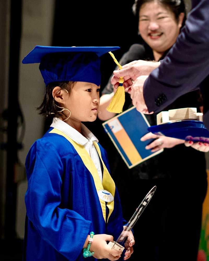 A little girl in a graduation cap and gown