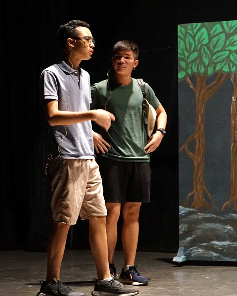 Two young men are standing next to each other on a stage.