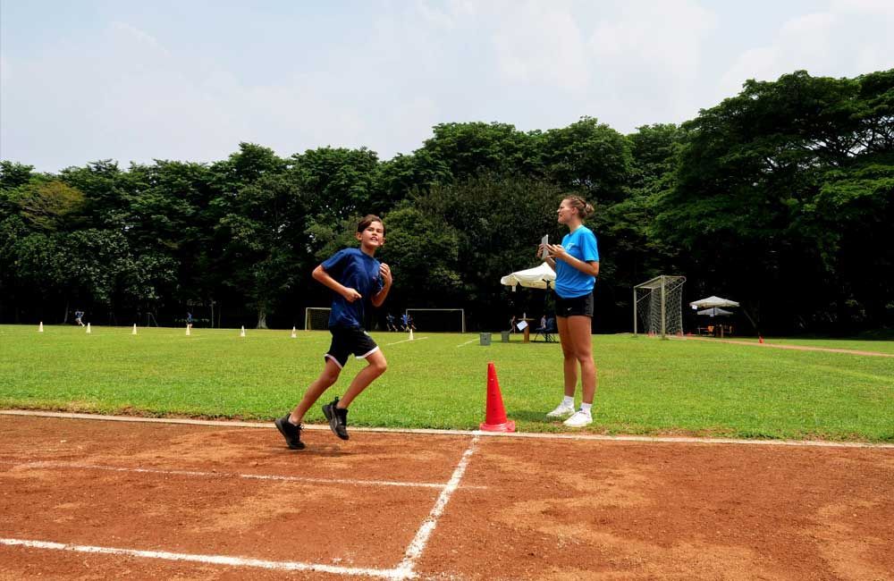 A boy and a girl are running on a track