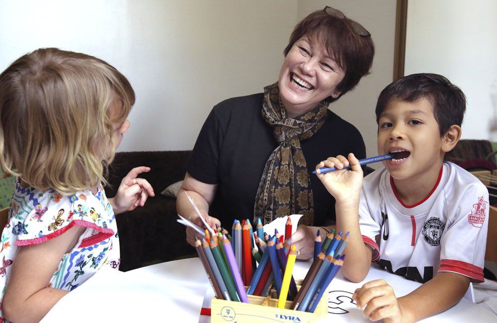 A Kindergarten teacher sharing a laugh with her students at the german School Jakarta
