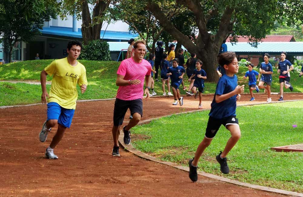 A group of people are running on a track in a park.