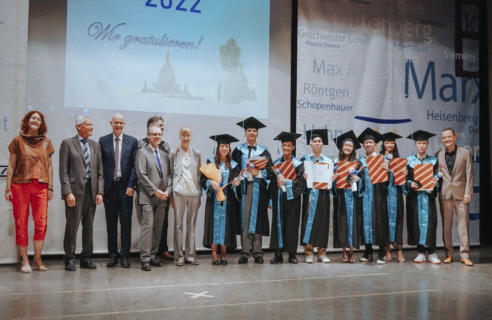A group of people in graduation caps and gowns are standing on a stage.