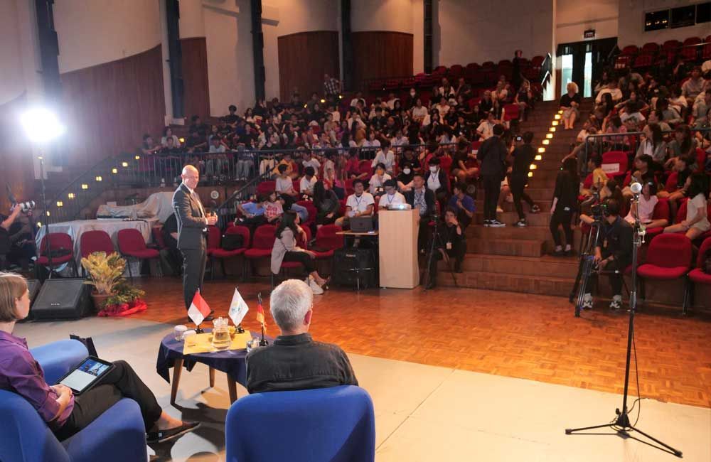A man is giving a speech in front of a crowd of people