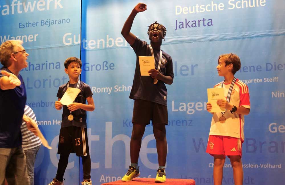 A man is standing on a podium holding a medal