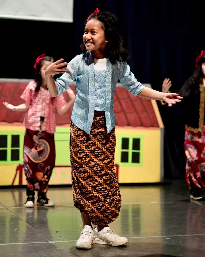A group of young girls are dancing on a stage
