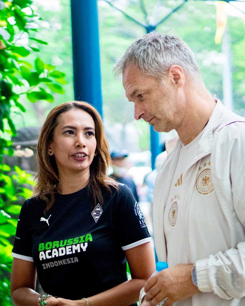 A man and a woman are standing next to each other and talking.