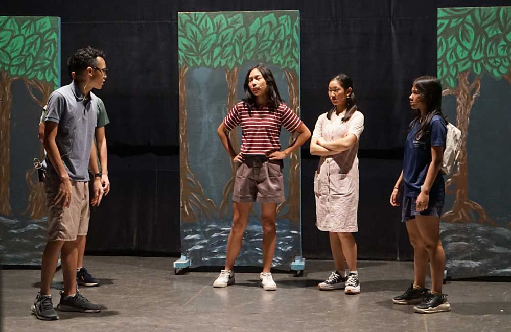 A group of people are standing on a stage talking to each other.