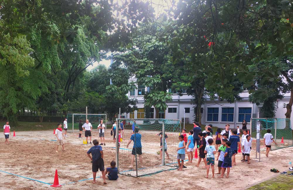 A group of children are playing volleyball in a park