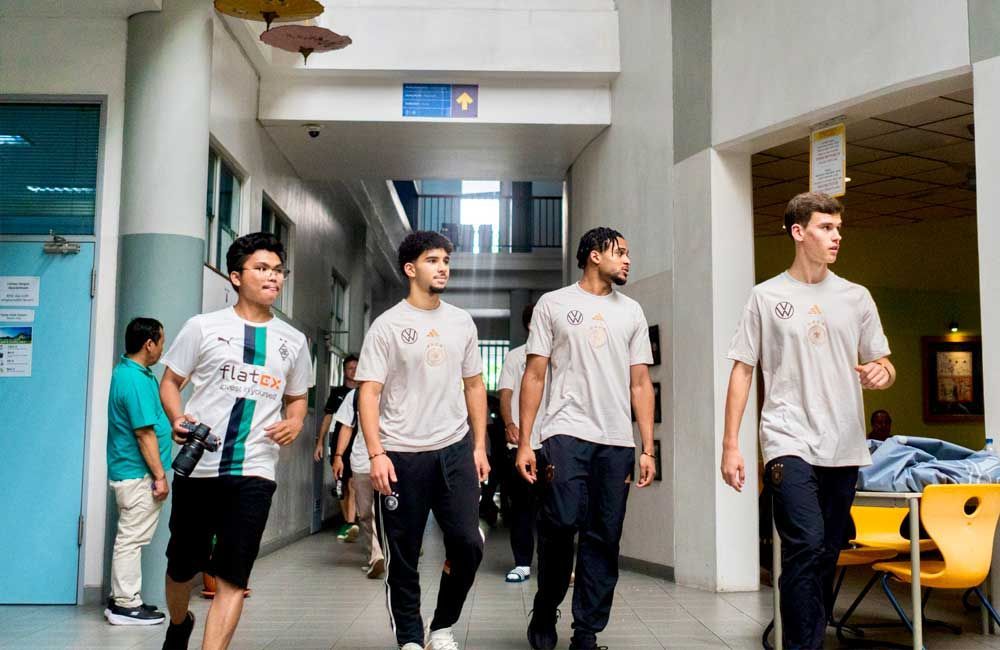 A group of young men are walking down a hallway.