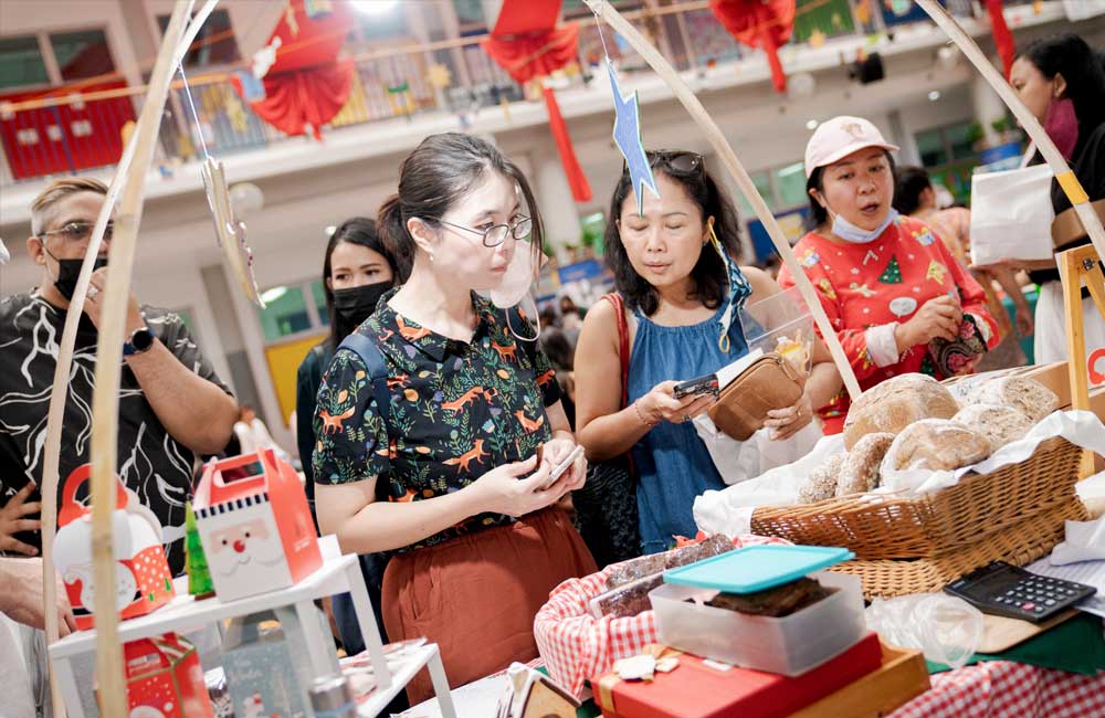 A group of people are standing around a table at a market.