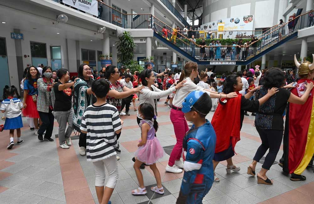 A group of people in costumes are dancing in a mall.