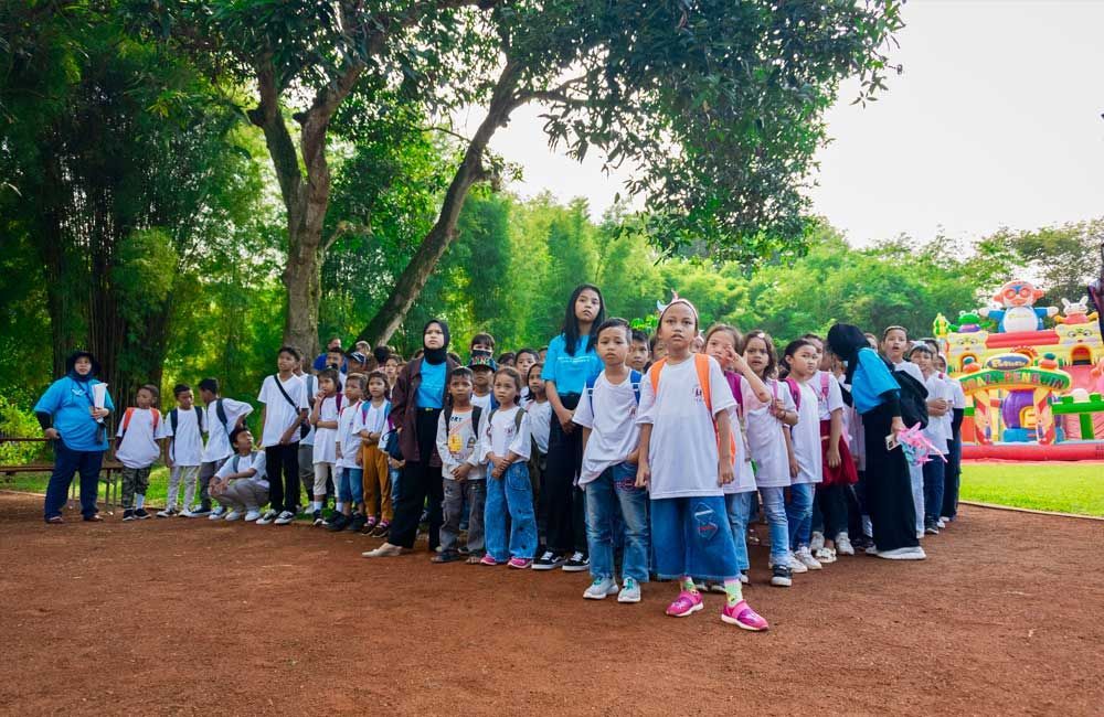 A large group of children are standing in a park.