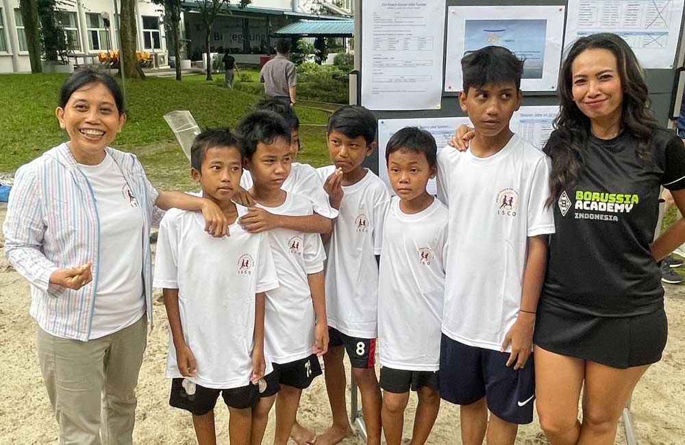 A group of children are posing for a picture with a woman.