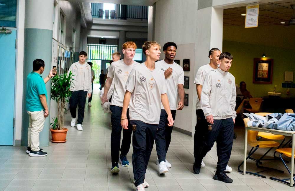 A group of young men are walking down a hallway in a school.