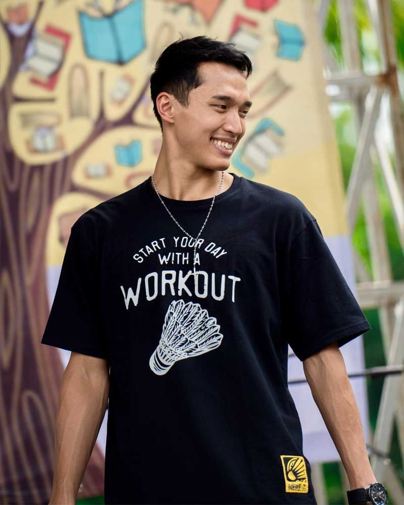 A man wearing a black t-shirt that says start your day with a workout