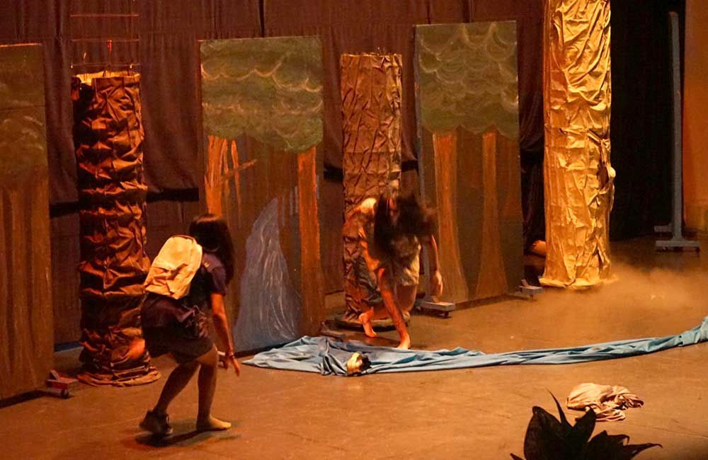 A group of people are standing on a stage in front of a curtain.