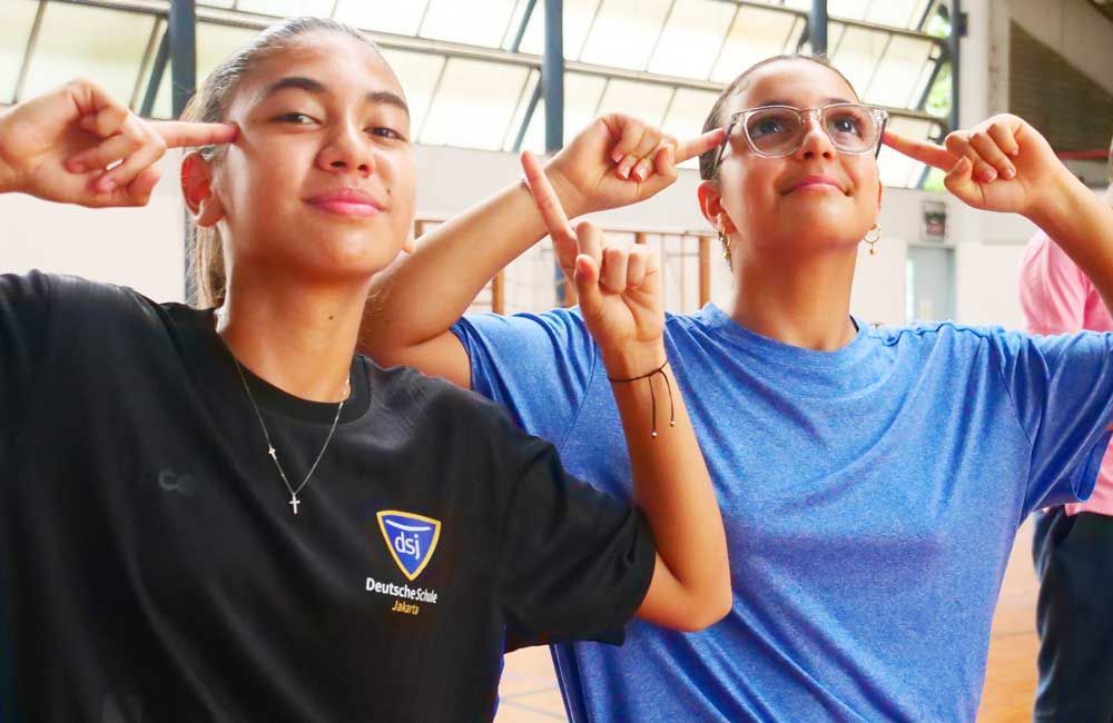 Two girls are covering their ears with their hands.